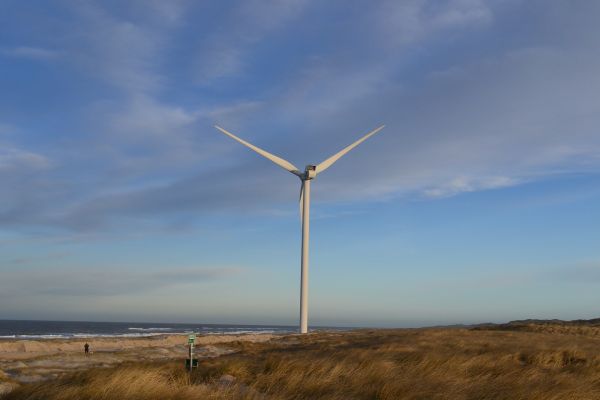 Windrad am Rande eines Strandes, Nachhaltigkeit auch in Corona-Zeiten